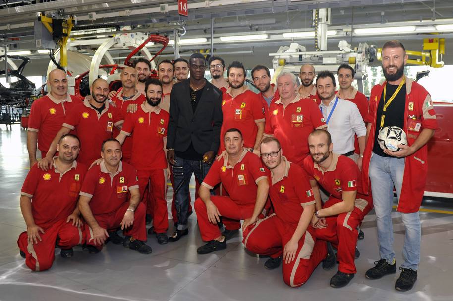 Mario Balotelli oggi in visita alla scuderia di Maranello. Ha visitato la fabbrica e ha parlato con gli operai della catena di montaggio. Poi si  messo in posa per l&#39;immancabile foto di gruppo nella casa del cavallino rampante.